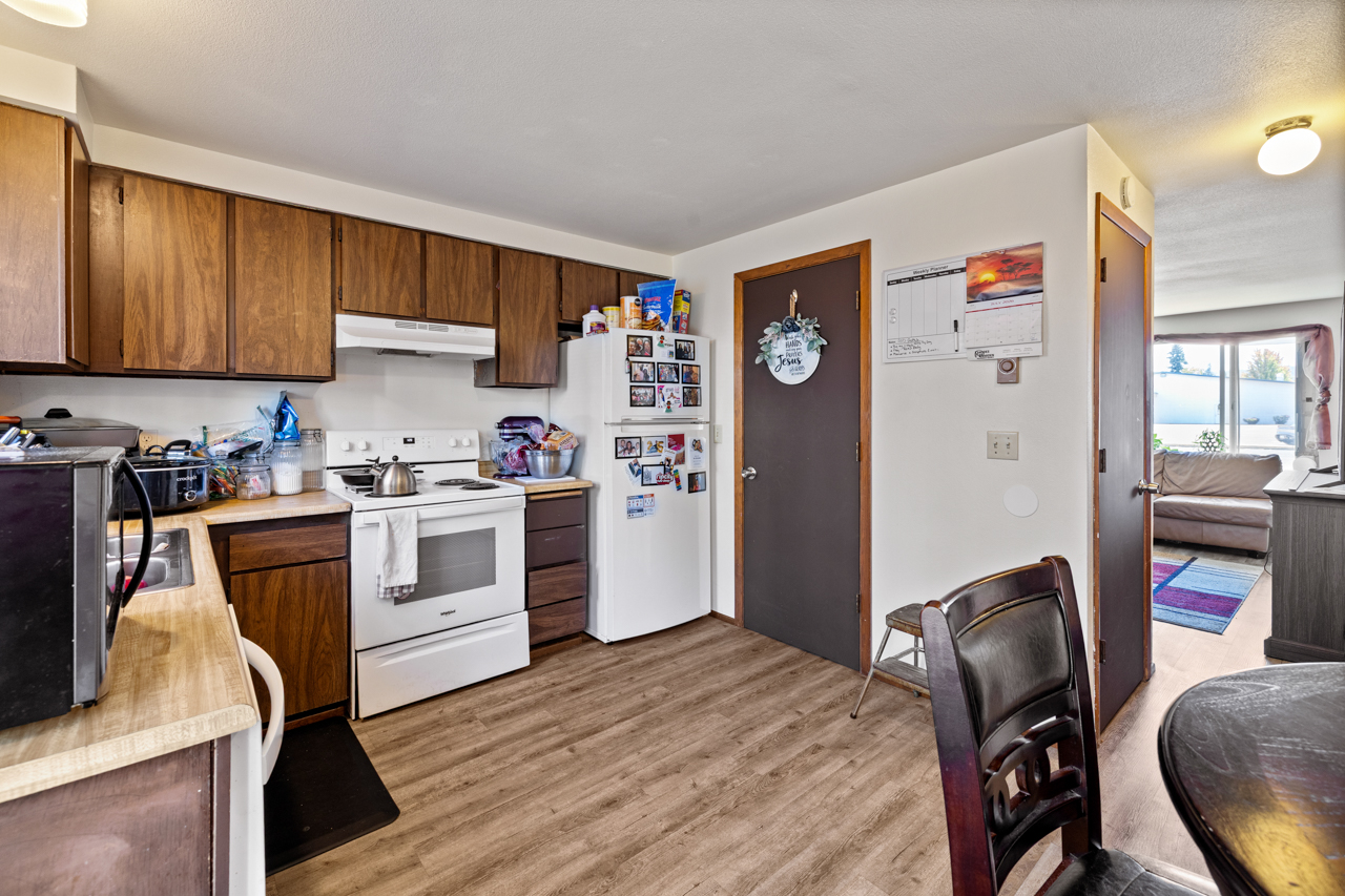 Unit kitchen with range, refrigerator, and dining area